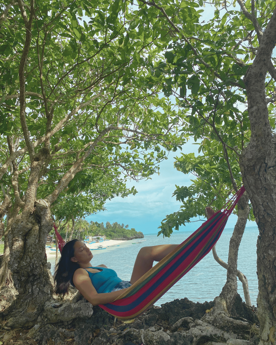 Lady on a Hammock surrounded by a serence background with Trees with an Ocean View