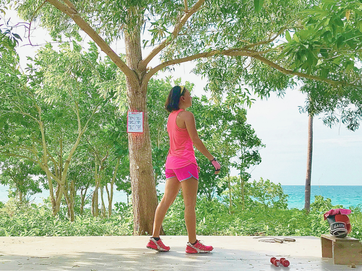 A woman in her workout clothes is starting her mom self-care journey by working out outdoors