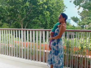 Mother holding a baby in her arms with a nature background