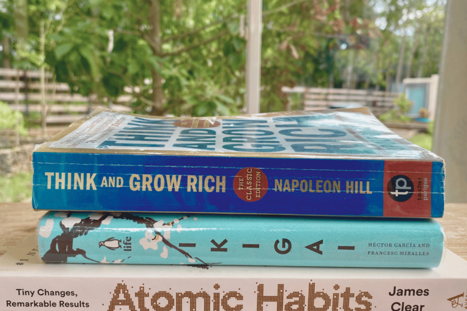 3 Must-Read Wellness Books for Mothers stacked on the table with a background of nature