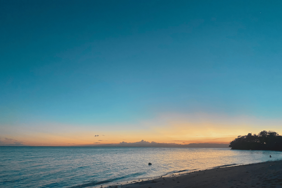 A breathtaking sunset by the beach, with golden-yellow and orange hues blending across the sky. A soft ray of light stretches over the horizon, casting a warm glow on the water—a serene reminder of life’s beauty and your own worthiness to experience and embrace it fully.