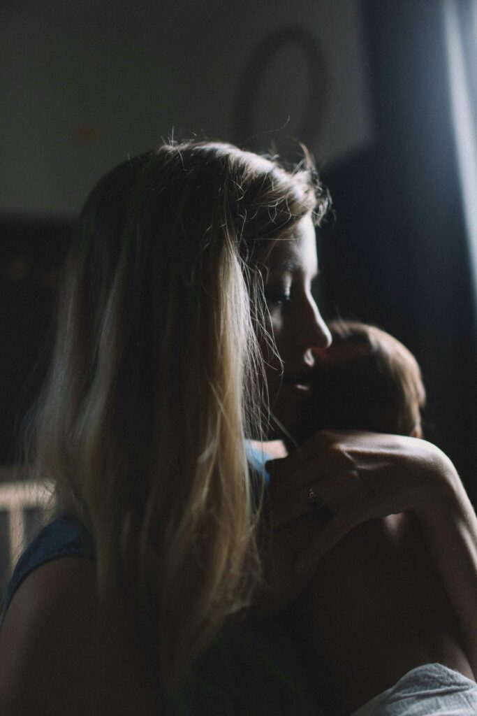 woman carrying baby looking sad going through postpartum