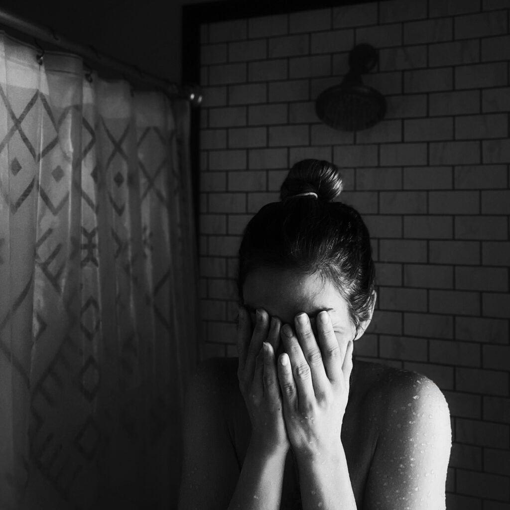 A mother crying in the bathroom due to postpartum depression 