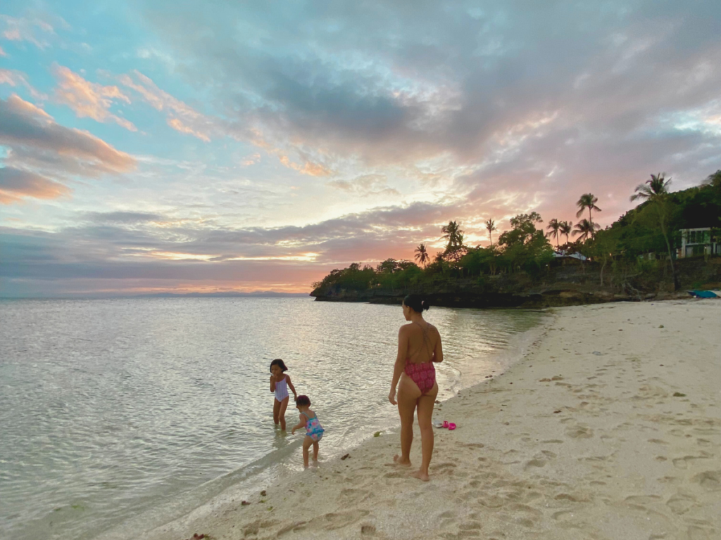 A mom going through healing in motherhood enjoying a wonderful time with her kids at the beach watching the sunset.