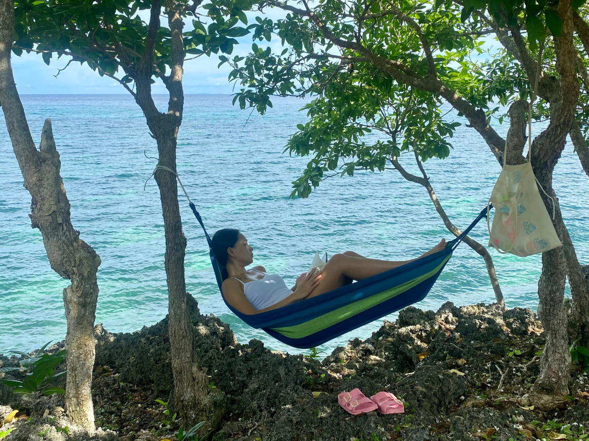Tired mom lying on a hammock, a quiet moment capturing the feeling of losing yourself in motherhood, gazing into the distance.