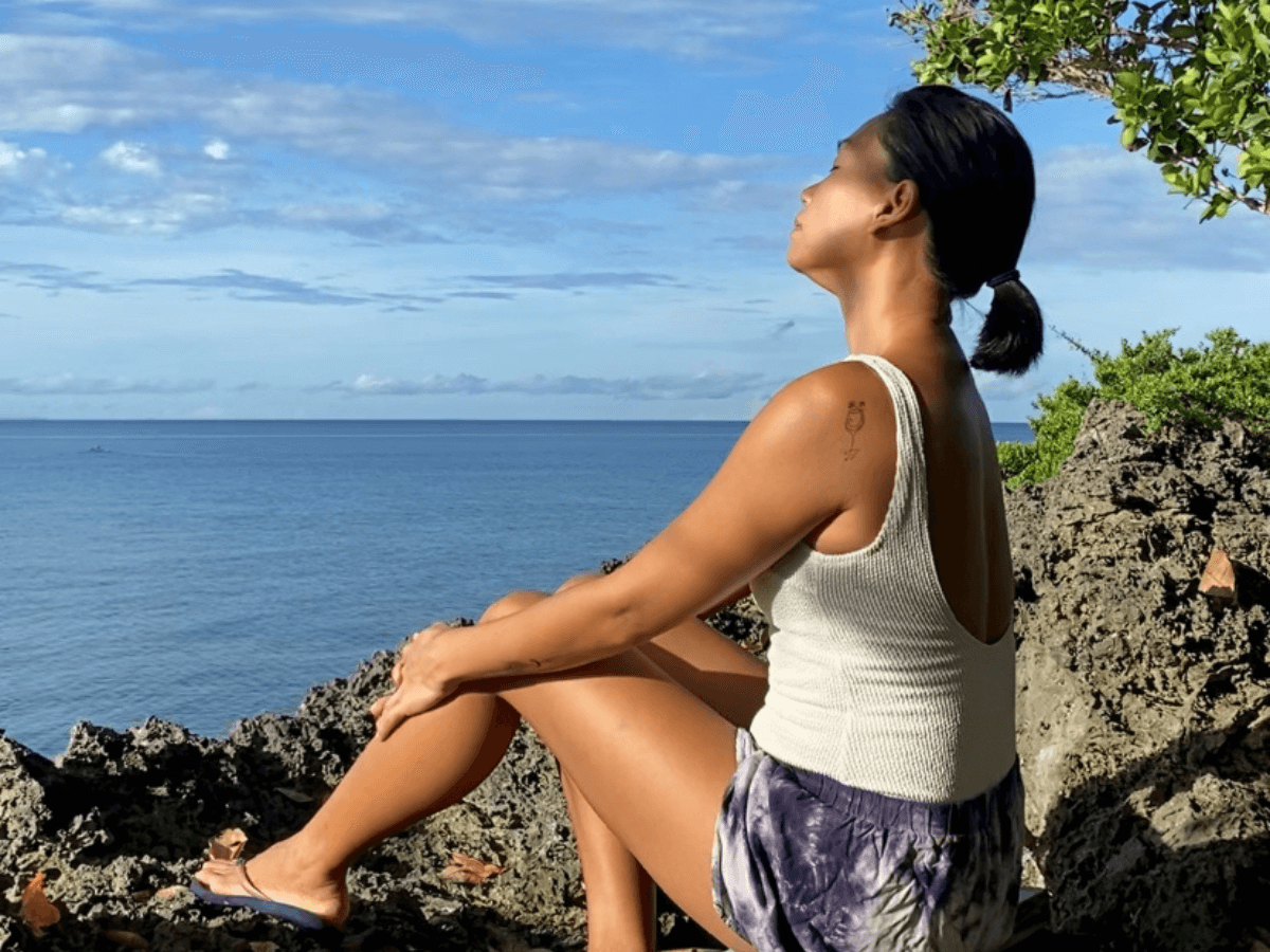 A mom spending quiet time in nature, looking calm and fulfilled after completing her morning routine easing the mental load of motherhood.