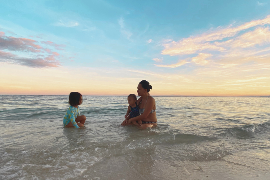 Giving up your career to be a stay-at-home mom can look like this: a mom with her two daughters enjoying the beach at sunset