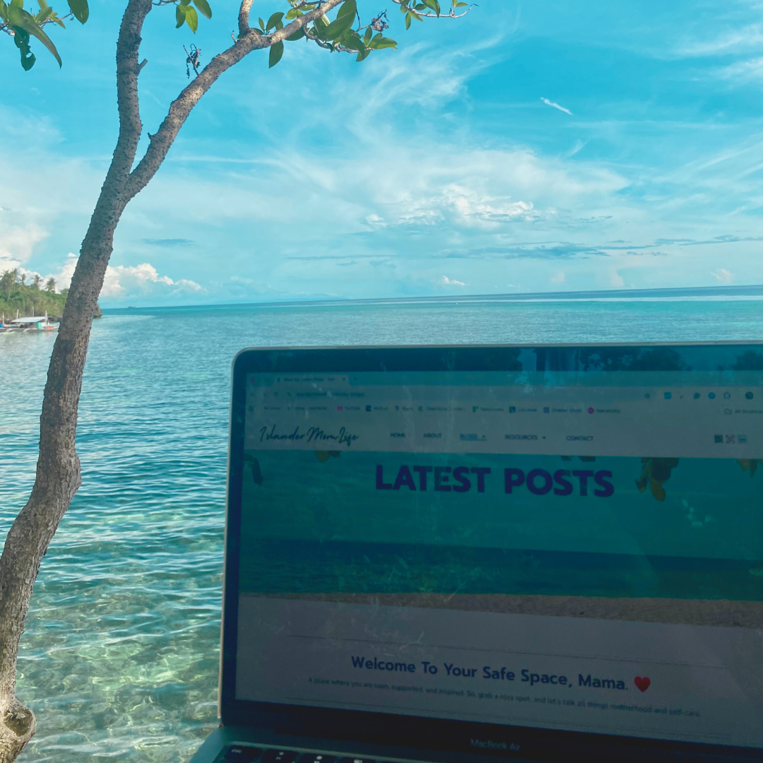 An open laptop on a table showing Islander Mom Life blog with the background of the ocean