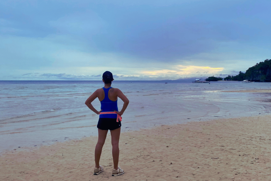 Ambitious moms represented by a woman doing a power pose at sunset after a run, showing strength, clarity, and identity beyond motherhood.