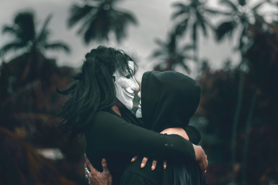 A couple embracing with masks on, representing subtle toxic relationship red flags hidden beneath affection and intimacy.