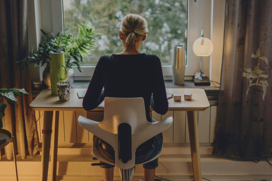 A mom sitting by the window working at home returning to work after motherhood