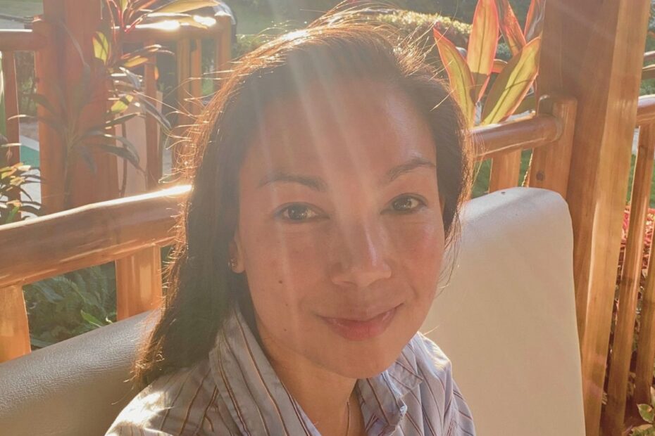 A smiling mom enjoying a peaceful sunset during her midlife awakening journey.