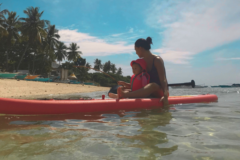 A mom on a stand-up paddle with her child figuring out how to find yourself again after having a baby