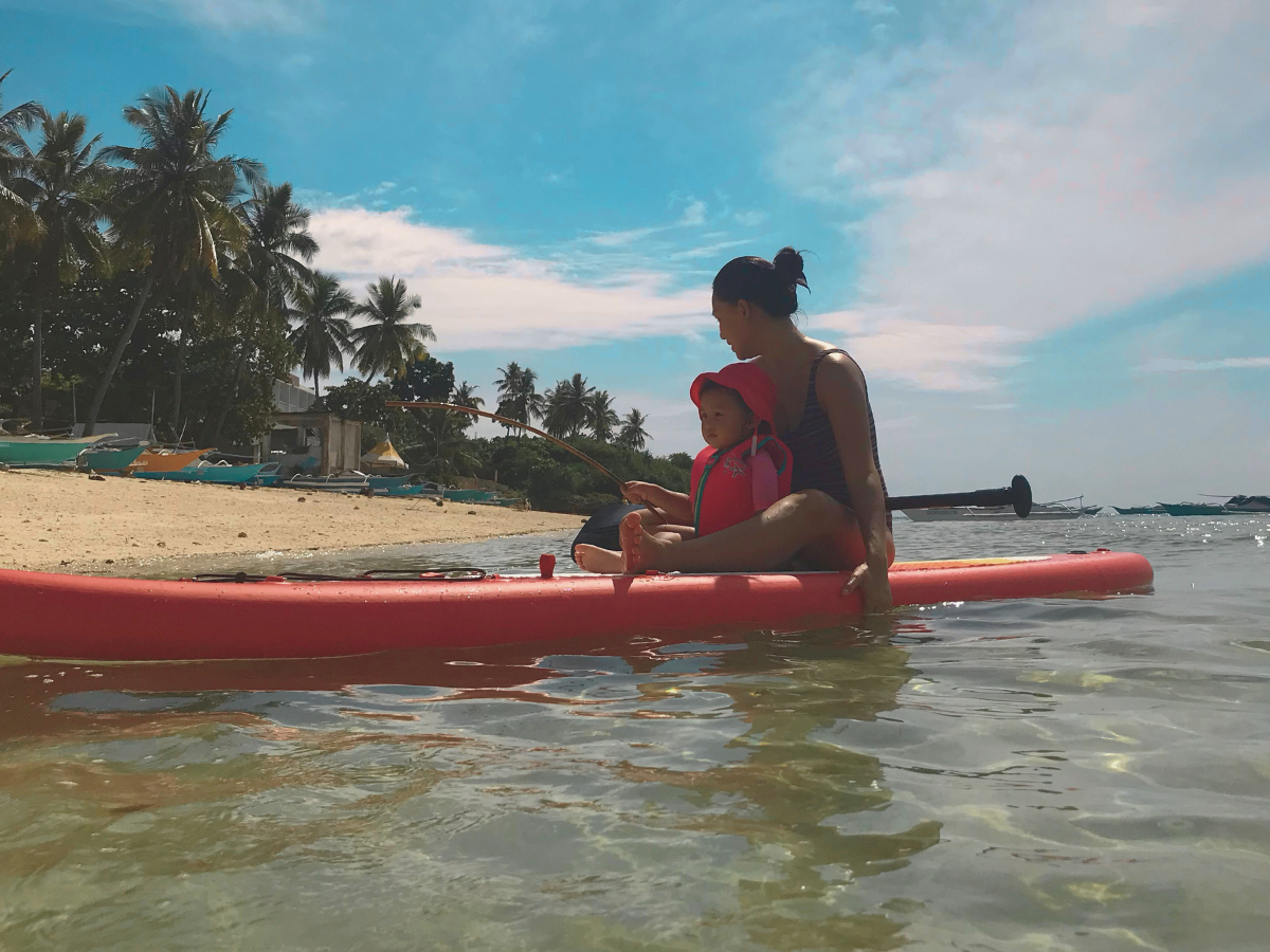A mom on a stand-up paddle with her child figuring out how to find yourself again after having a baby